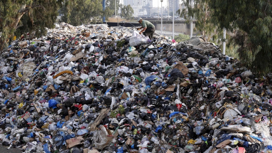 A scavenger sifts through garbage piled on the bank of Beirut river, Lebanon, on Aug. 24, 2015. A scavenger sifts through garbage piled on the bank of Beirut river, Lebanon, on Aug. 24, 2015.